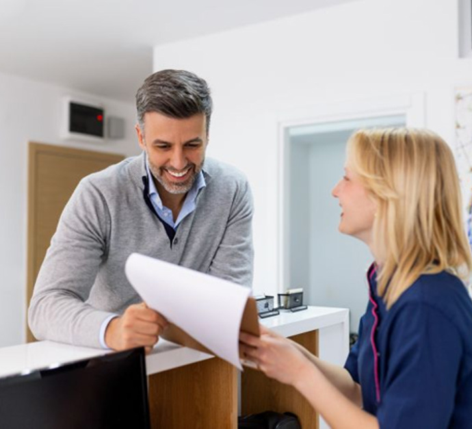 Dental team member assisting patient at front desk