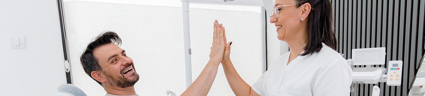 Happy patient high-fiving dental team member