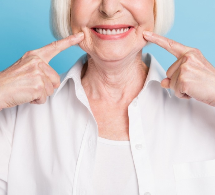 Senior woman pointing to her smile
